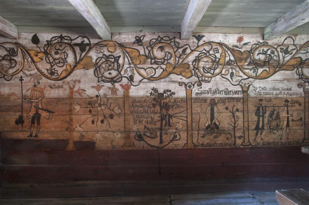 Tonstadbua fra Tonstad i Sirdal. Dette huset ble tidligere brukt som ventebu nede ved dampskipsbrygga. Veggene inne i bua er dekorert med bibelske motiver av den kjente rosemaleren Tore Asbjørnsen Risøyne i 1780. Tonstadbua ble overført til Vest Agder fylkesmuseum i 1967.
