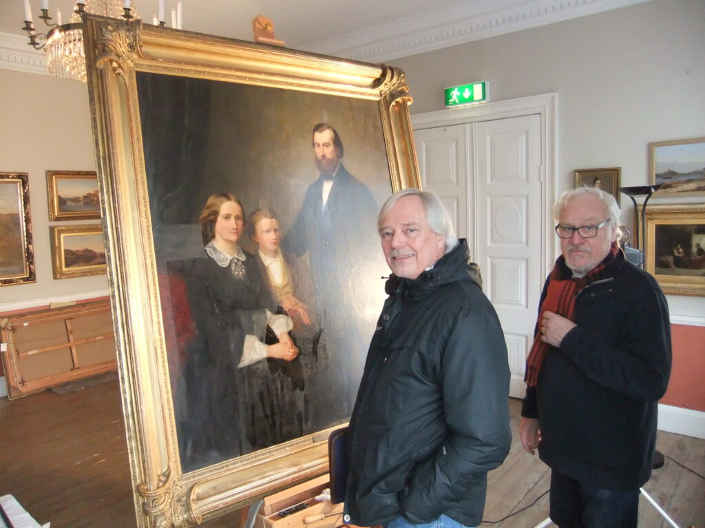 Adolph Tidemands familieportrett regnes som ett av hans hovedverker. Enhetsleder for allmennkultur Jon Røkland og konservator Svein A. Wiik studerer maleriet.
