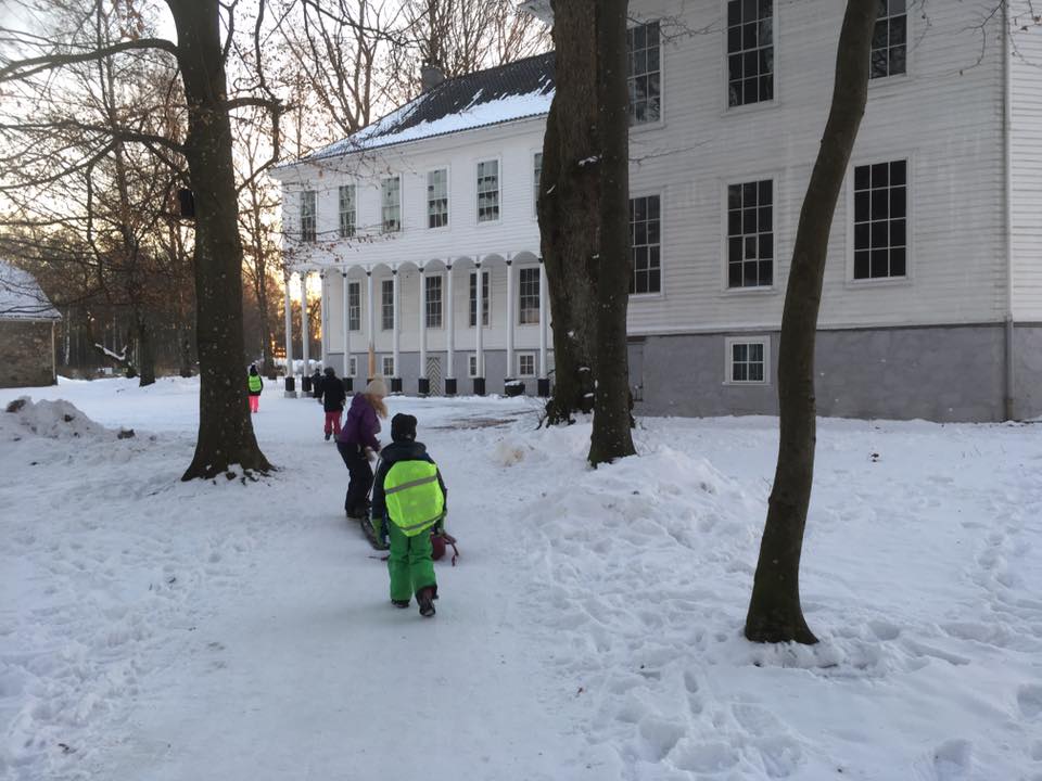 Bilde fra utsiden av Gimle Gård på vinter, avbildet med skolebarn 