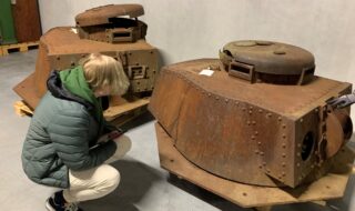Student og artikkelforfatter Oliver Strøm Reitan inspiserer pansertårnene i Vest-Agder-museets mangasin