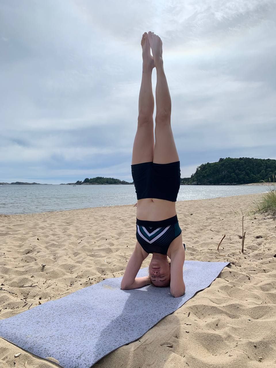 Ganna fra Ukraina driver yoga på stranda