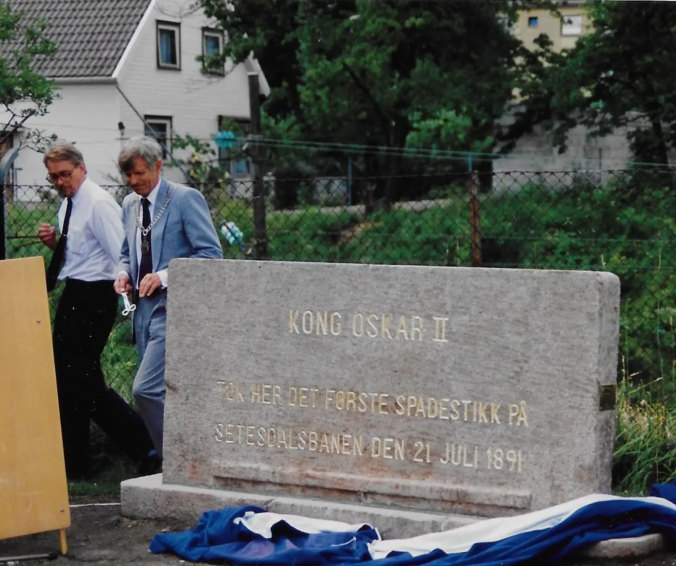 Avdukingen av Minnesteinen etter det første spadestikk for Setesdalsbanen etter at den var flyttet til Falkentomta på Grim i 1991. Fotograf Knut John Bakken.
