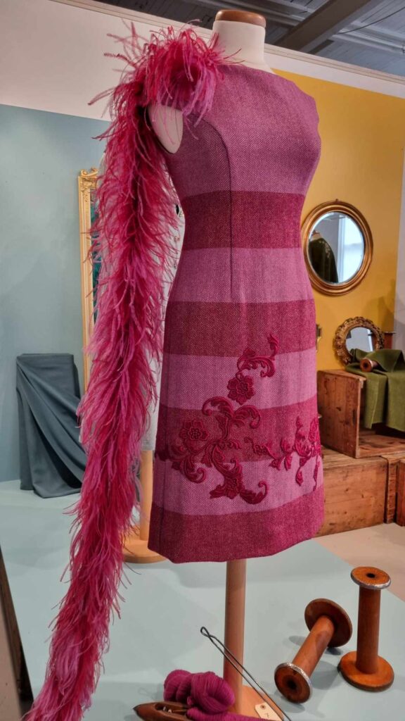 Burgunderrosa kjole i fiskebensvevd ull med blondeapplikasjoner. Ove Harder Finseth Sjølingstad Uldvarefabrik