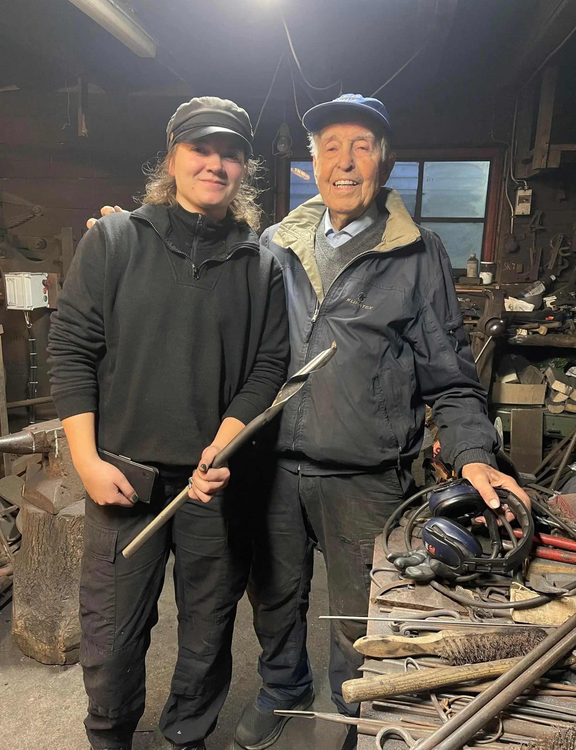 Navarsmed Ida Moi står med lærermester Johannes. I hånden holder Ida en halv meter lang navar borr.