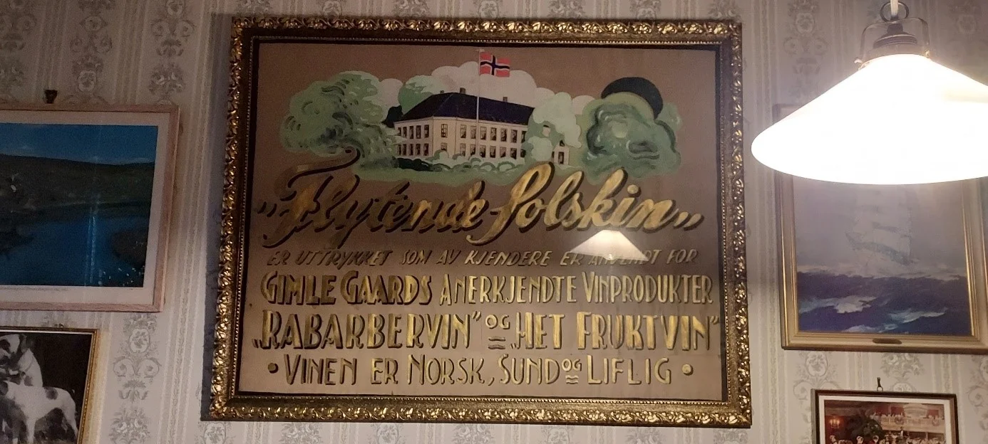 Reklameplakat i gullramme for vin fra gimle